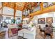 Bright living room with vaulted ceilings, wooden beams, and a cozy fireplace, offering a spacious and inviting atmosphere at 8191 S Homesteader Dr, Morrison, CO 80465