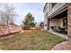 Well-maintained backyard with lush lawn, stone pavers, covered patio, and barbecue area at 9591 Sunset Hill Dr, Lone Tree, CO 80124