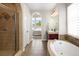 Bathroom showcasing a glass enclosed shower, soaking tub, and vanity with granite countertops at 9591 Sunset Hill Dr, Lone Tree, CO 80124