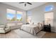 Bright bedroom with large windows, hardwood flooring, and a cozy sitting area by the window at 9591 Sunset Hill Dr, Lone Tree, CO 80124