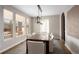 Dining room with rustic wood table, white chairs, modern chandelier, and plenty of natural light at 9591 Sunset Hill Dr, Lone Tree, CO 80124