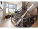 Grand foyer with a beautiful staircase, stone accent wall, hardwood floors, and ample natural light at 9591 Sunset Hill Dr, Lone Tree, CO 80124