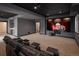Spacious home theater featuring tiered seating, large projection screen, and a stylish wet bar area at 9591 Sunset Hill Dr, Lone Tree, CO 80124