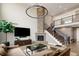 Spacious living room features stone fireplace, modern lighting, staircase, and comfortable seating area at 9591 Sunset Hill Dr, Lone Tree, CO 80124