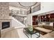 Bright living room with stone fireplace, high ceilings, wrought iron railings, and open concept to the kitchen at 9591 Sunset Hill Dr, Lone Tree, CO 80124