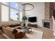 Vaulted living room with a stunning stone fireplace, large windows, and a comfortable seating arrangement at 9591 Sunset Hill Dr, Lone Tree, CO 80124