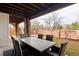 Covered patio with stone columns and elegant outdoor dining set at 9591 Sunset Hill Dr, Lone Tree, CO 80124