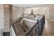 View of second story with staircase with dark railings overlooking an open floor plan at 9591 Sunset Hill Dr, Lone Tree, CO 80124