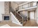Elegant staircase featuring wood steps, iron railing, and a stone fireplace in the living area at 9591 Sunset Hill Dr, Lone Tree, CO 80124
