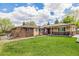 Expansive backyard with lush lawn, a garden trellis, and comfortable seating areas, perfect for relaxation and outdoor entertaining at 7777 Newman St, Arvada, CO 80005