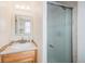 This half bathroom features tile floors, wooden cabinets, and a glass shower door at 7777 Newman St, Arvada, CO 80005