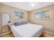 This bedroom offers dual windows for natural light, a ceiling fan, and hardwood floors at 7777 Newman St, Arvada, CO 80005