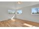 Spacious bedroom featuring gleaming hardwood floors and three large windows at 3901 Newland St, Wheat Ridge, CO 80033