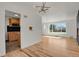 Open-concept living area with hardwood floors, a modern light fixture, and kitchen access at 3901 Newland St, Wheat Ridge, CO 80033