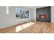 Bright living room with hardwood floors, a modern fireplace and a view of the front yard at 3901 Newland St, Wheat Ridge, CO 80033