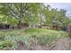 Landscaped backyard featuring garden beds and mature trees at 2556 S Eagle Cir, Aurora, CO 80014
