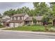 Charming two-story home with a brick facade, well-maintained lawn, mature trees, and a driveway leading to a two-car garage at 2556 S Eagle Cir, Aurora, CO 80014