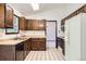 Well-lit kitchen features dark wood cabinets, modern appliances, and easy access to the dining area at 2556 S Eagle Cir, Aurora, CO 80014