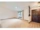 Bright living room features a large window, neutral carpet, and a dark wood front door with tile entry at 2556 S Eagle Cir, Aurora, CO 80014