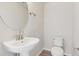 Simple powder room with a pedestal sink, round mirror, and elongated toilet at 457 Interlocken Blvd # 103, Broomfield, CO 80021