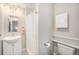 Clean bathroom featuring a shower with a curtain, a sink vanity, and a toilet with convenient shelving at 8299 E Kenyon Ave, Denver, CO 80237