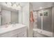 Clean bathroom featuring a modern vanity and a walk-in shower with gray tiling at 8299 E Kenyon Ave, Denver, CO 80237