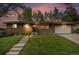 Charming single-story brick home with a well-manicured lawn and inviting curb appeal at sunset at 8299 E Kenyon Ave, Denver, CO 80237