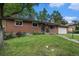 Charming brick home featuring a well-manicured lawn and an attached garage under a bright blue sky at 8299 E Kenyon Ave, Denver, CO 80237