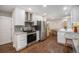 Modern kitchen featuring stainless steel appliances, granite countertops, white cabinets, and hardwood floors at 8299 E Kenyon Ave, Denver, CO 80237