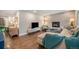 Bright living room with wood floors, a tiled fireplace, a comfortable sectional sofa, and plenty of natural light at 8299 E Kenyon Ave, Denver, CO 80237