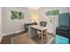 Home office space with natural light from two windows, hardwood floors, and modern furniture at 8299 E Kenyon Ave, Denver, CO 80237