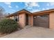 Brick ranch home with a brown garage door and landscaping at 8661 W 32Nd Pl, Wheat Ridge, CO 80033