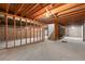 Unfinished basement with exposed wooden beams, concrete floor, and block foundation walls at 8661 W 32Nd Pl, Wheat Ridge, CO 80033