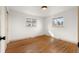 Well-lit bedroom with hardwood floors, base trim, and two windows overlooking the yard at 8661 W 32Nd Pl, Wheat Ridge, CO 80033
