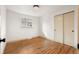 Neutral bedroom with hardwood floors, a window, and closet featuring sliding doors at 8661 W 32Nd Pl, Wheat Ridge, CO 80033