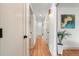 Hallway featuring hardwood floors, white walls, and doors leading to the various rooms at 8661 W 32Nd Pl, Wheat Ridge, CO 80033