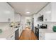 Open kitchen featuring stainless steel appliances, white cabinets, and hardwood floors at 8661 W 32Nd Pl, Wheat Ridge, CO 80033