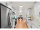 Modern kitchen featuring stainless steel appliances, white cabinets, and hardwood flooring at 8661 W 32Nd Pl, Wheat Ridge, CO 80033