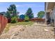 Property featuring a spacious backyard with mature trees, a patio, and a stone border at 4422 E Andover Ave, Castle Rock, CO 80104