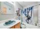 Bathroom featuring a unique blue sink, decorative shelves and toilet, and patterned shower curtain at 4422 E Andover Ave, Castle Rock, CO 80104