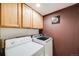 Laundry room with white washer and dryer and tan cabinets above at 4422 E Andover Ave, Castle Rock, CO 80104
