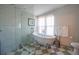 Charming bathroom features claw foot tub, glass shower and checkerboard floors at 5541 Umatilla St, Denver, CO 80221