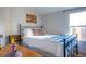 Bright bedroom features a full-sized bed with metal frame, wood accents, and warm natural light at 5541 Umatilla St, Denver, CO 80221