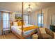 Bright bedroom features four poster bed, light colored walls and wood flooring at 5541 Umatilla St, Denver, CO 80221