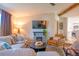 Cozy living room featuring a decorative fireplace, comfortable seating, and lots of natural light at 5541 Umatilla St, Denver, CO 80221