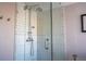 Modern glass enclosed shower is finished with white tile and chrome fixtures at 5541 Umatilla St, Denver, CO 80221