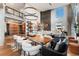 Spacious living room with a large dining table, custom shelving, and a climbing wall at 1610 Little Raven St # Ph6, Denver, CO 80202
