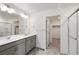 Bright bathroom features a double vanity, grey cabinetry, and a separate shower and closet at 4743 Hatcher Dr, Brighton, CO 80601