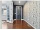 Inviting entryway featuring hardwood floors, a dark accent wall, and decorative birch-themed wallpaper at 3438 Cade Ct, Castle Rock, CO 80104