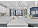 A stylish white farmhouse sink and brass faucet sits beneath pendant lighting on a quartz countertop at 3438 Cade Ct, Castle Rock, CO 80104